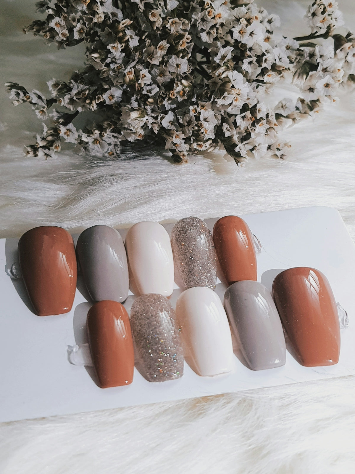 six different colors of nail polish on a white surface