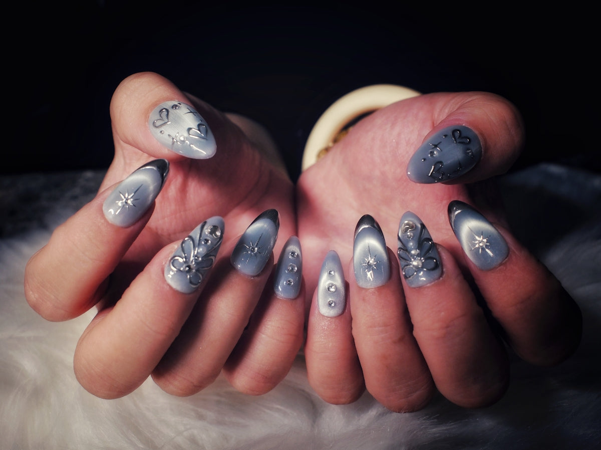 Woman's hands with elegant grey cat-eye nails.